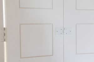 Three panel folding shutter in closed position - Iroko Teak | McNally Cream Finish | Shutters | Painted Hinges