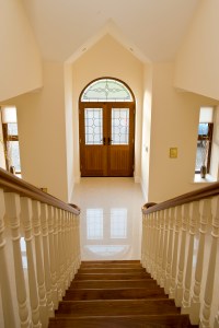 Down stairs view of arched fanlight double transom door