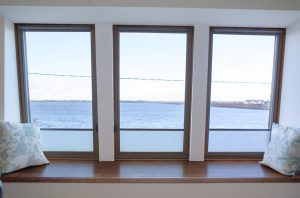 View of ocean - windows with wooden frame - interior window seat and window sill