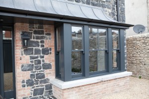 double hung sliding sash windows - black window frame - cement exterior window sill - black stone and brick wall