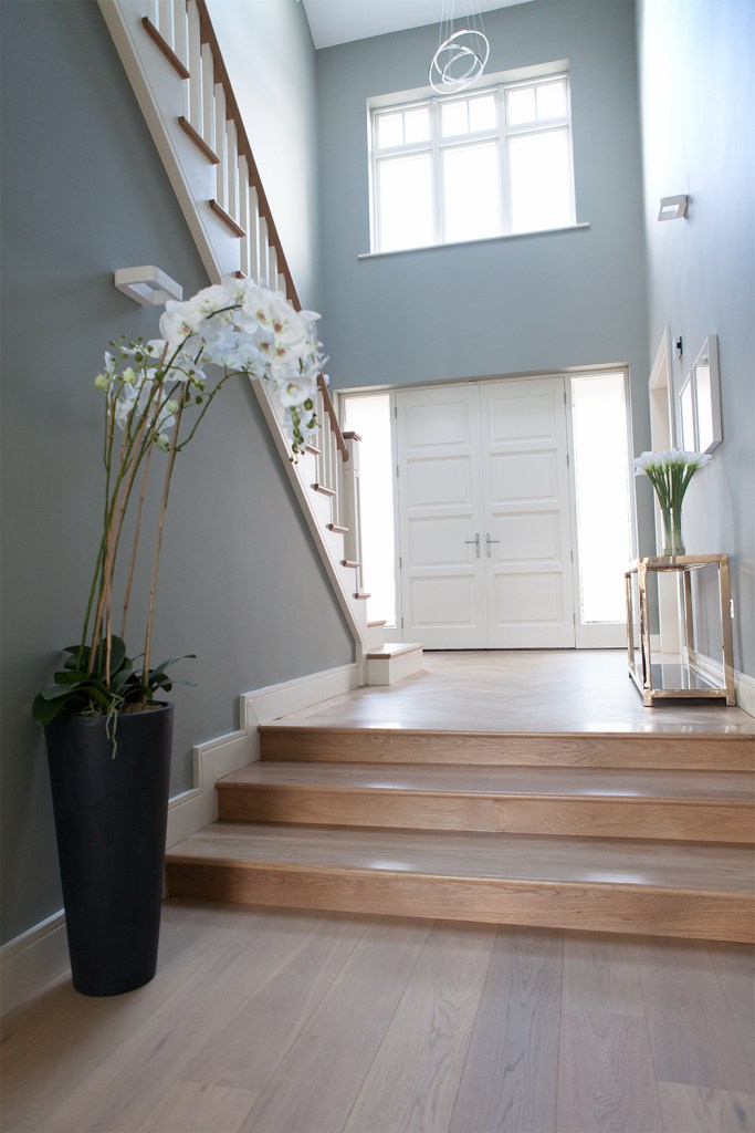 Entrance hallway featuring McNally Joinery steps, front door and staircase - wooden stairs