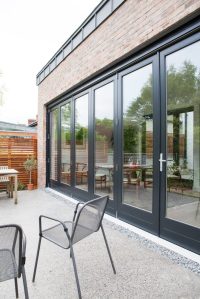 Black frame on closed bi-fold door and brick casing