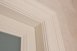 Close up of door corner with white frame and casing