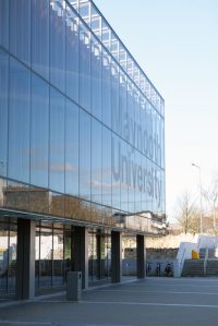 Glass window wall of university of Maynooth - parking lot view