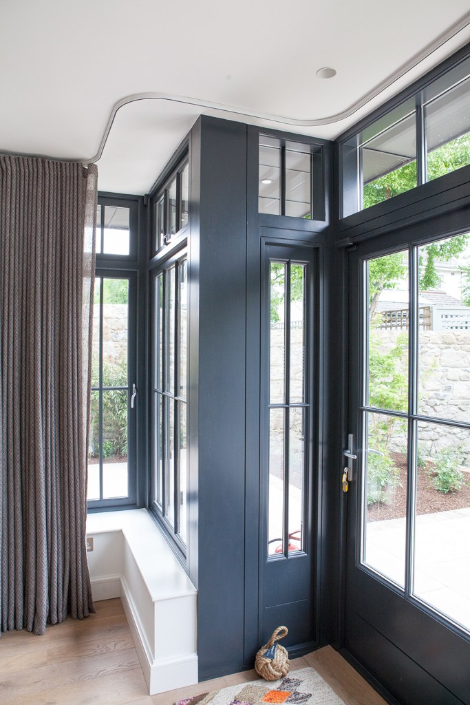 black sidelite windows with black frame and grille - sliding door with windows - white interior window sill - open sliding curtains