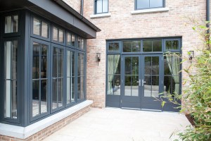 Black window frames and grilles - fanlight window - double glass door with sidelites and fanlight windows - brick wall