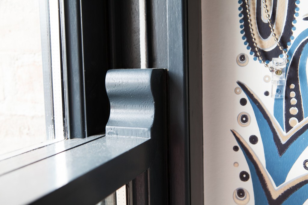 close up of carved window frame - black window frame - double hung window