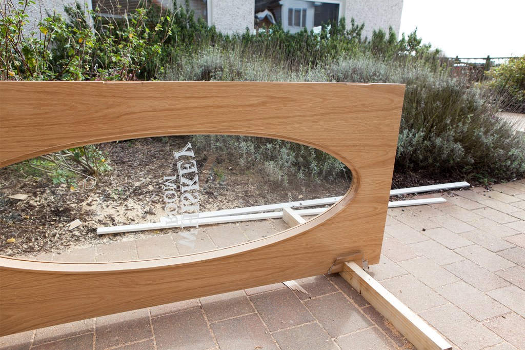 front door with window and sandblasted name laying on its side outside