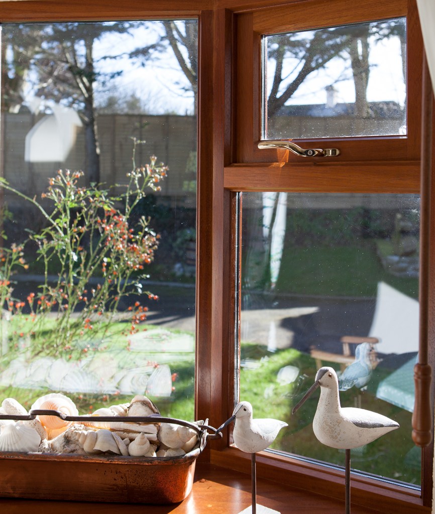 Wooden decor birds in window sill - shells in a holder - windows with fanlight - garden