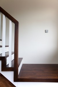 chocolate color wood - dark wood staircase landing and handrail - white wood baluster - white stair risers - dark wood stair string