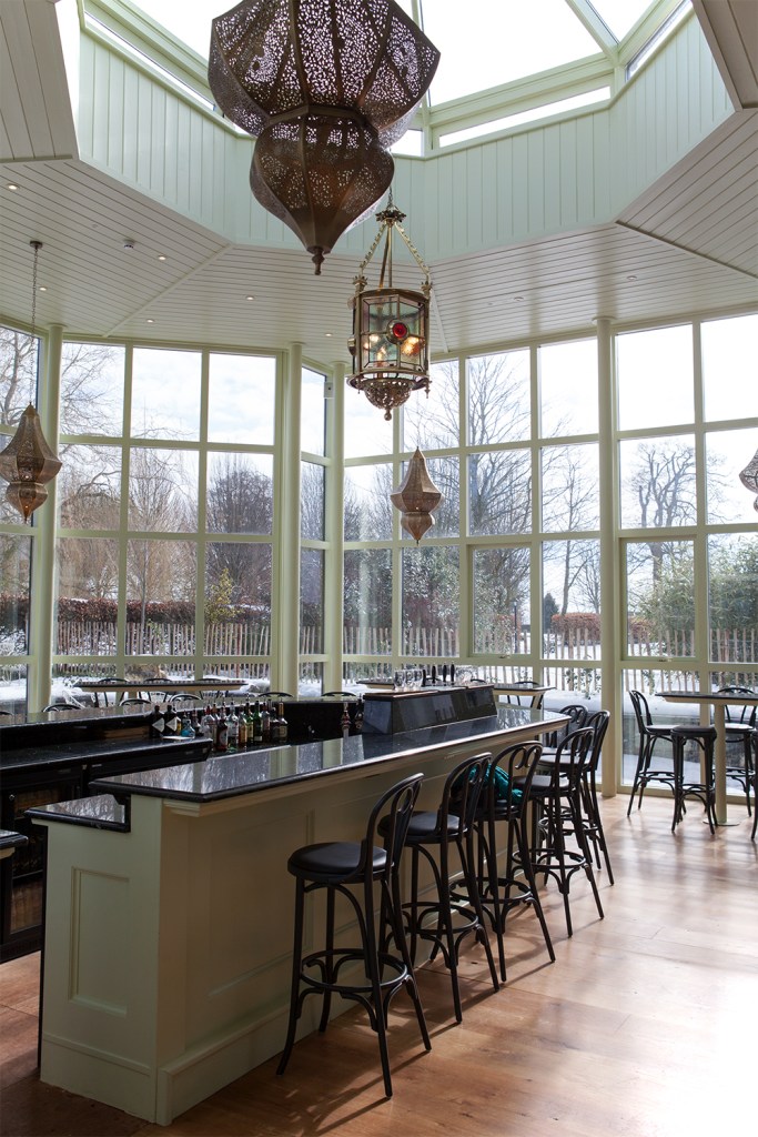 Window walls - window ceiling - bar counter with bar chairs - decorative lights hanging - wooden floor