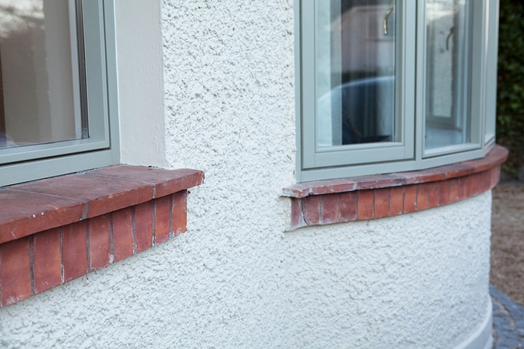 Red brick window sill - green window frame and casing