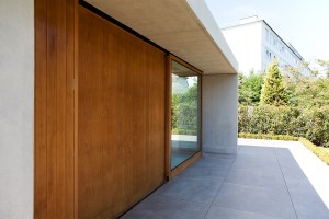 Closed sliding glass door - sheeted wood wall - outside view - extended roof and casing