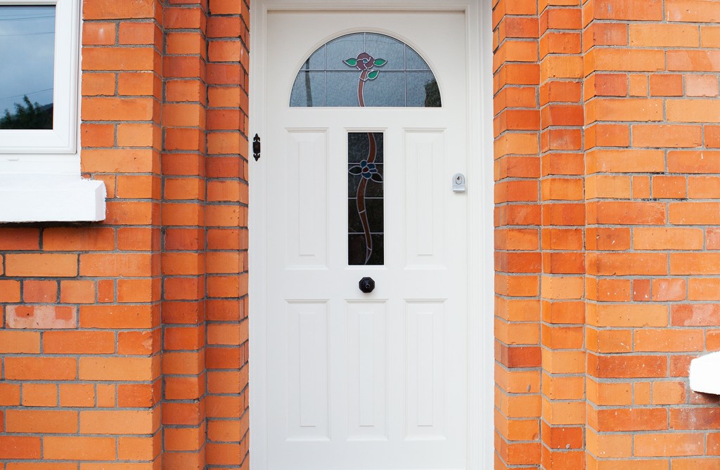 Red brick house with white door - rose stained glass door - white door frame and casing