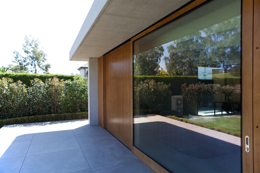 Sliding door with wooden frame and glass window - sheeted wood wall - extended roof