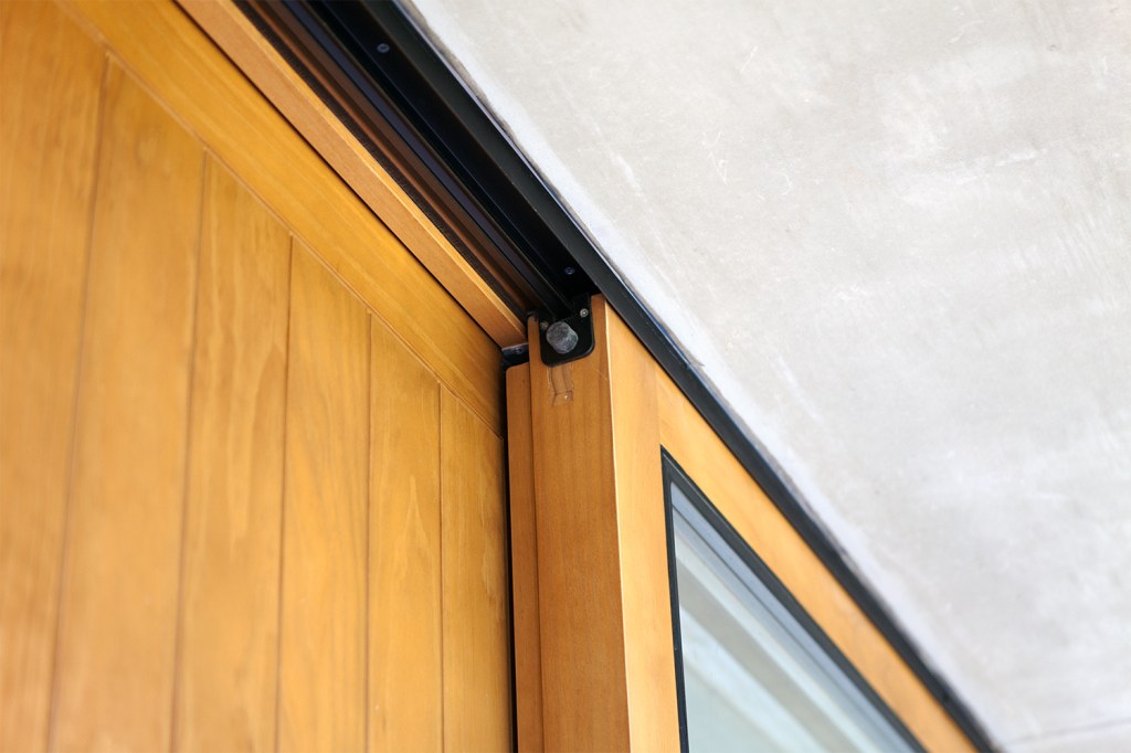 Black sliding door rail - sheeted wood door - wood door frame - black door casing