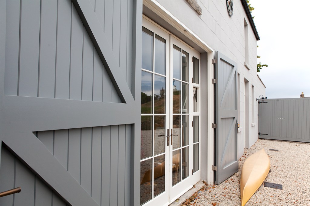 Glass double door with white frame and grills - open grey wooden double doors - yellow kayak