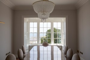 Dining room with crystal chandelier - double hung windows with white frame and casing - dining room set