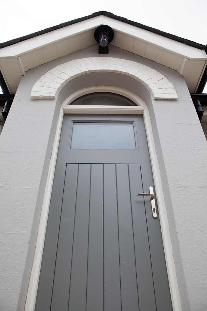 Transom fanlight window above door - curved brick frame - porch light - silver door handle