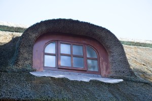 Rural danish thatched roof - curved window with wooden frame