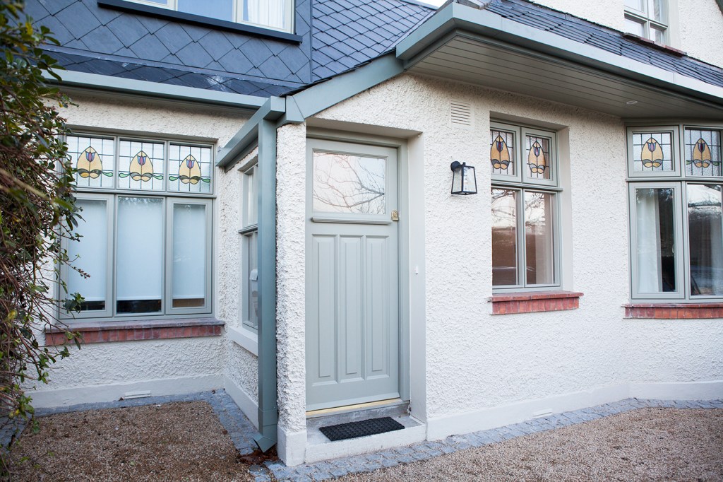 Mint green front door - transom door - mint green window frames - windows with stained glass fanlight windows - green gutters