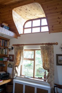 Fanlight window with sheeted wood ceiling and casing - wood window frame - curtains opened