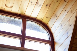 Transom ceiling window corner with wooden frame and sheeted wood ceiling