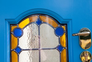 Blue door with carved arched stained glass window - yellow and blue stained glass window - silver door handle and key cylinder