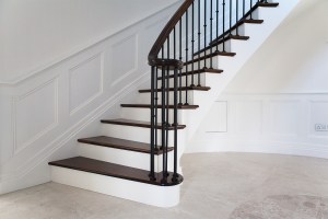 White structural cut stringer - white stair riser - dark wood stair tread - white wall panel
