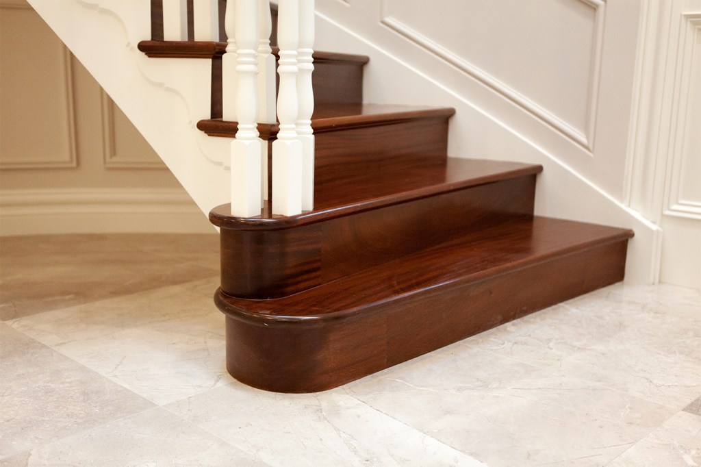 wooden staircase curtail - starting step - dark wood staircase with white wood balustrade