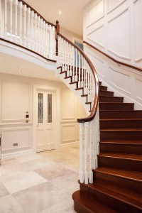 Curved chocolate wood staircase with white baluster and dark wood handrail