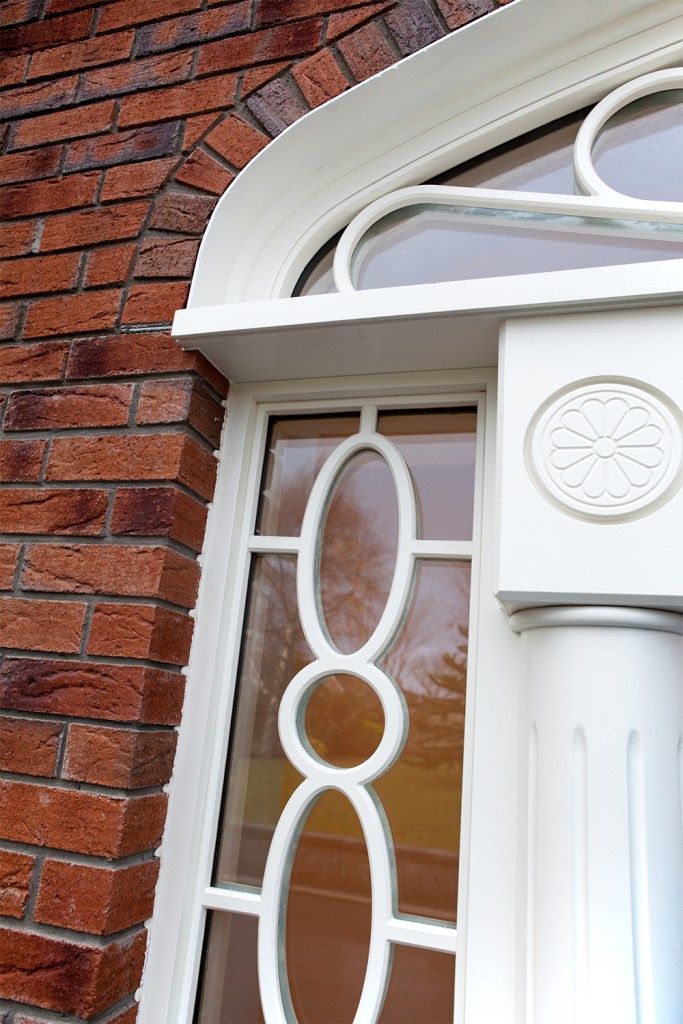 Sidelites with white curved grills and a white door frame - red brick casing