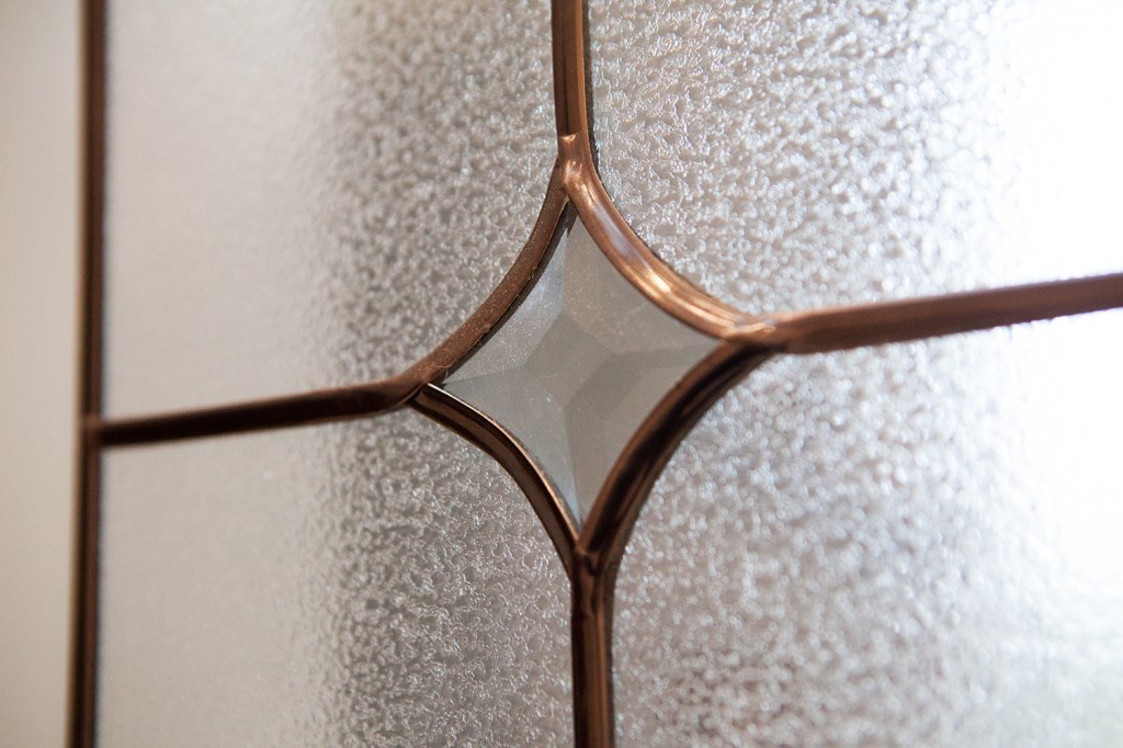 Close up photo of curved style bronze window grille