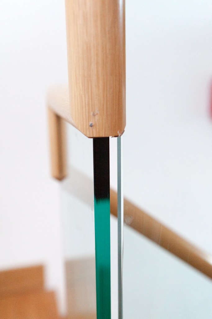 Close up photo of glass balustrade and wooden handrail