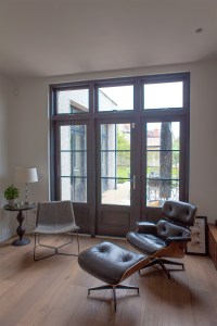 Transom windows above door - wooden door frame - door with panels and grilles - office chair - foot rest