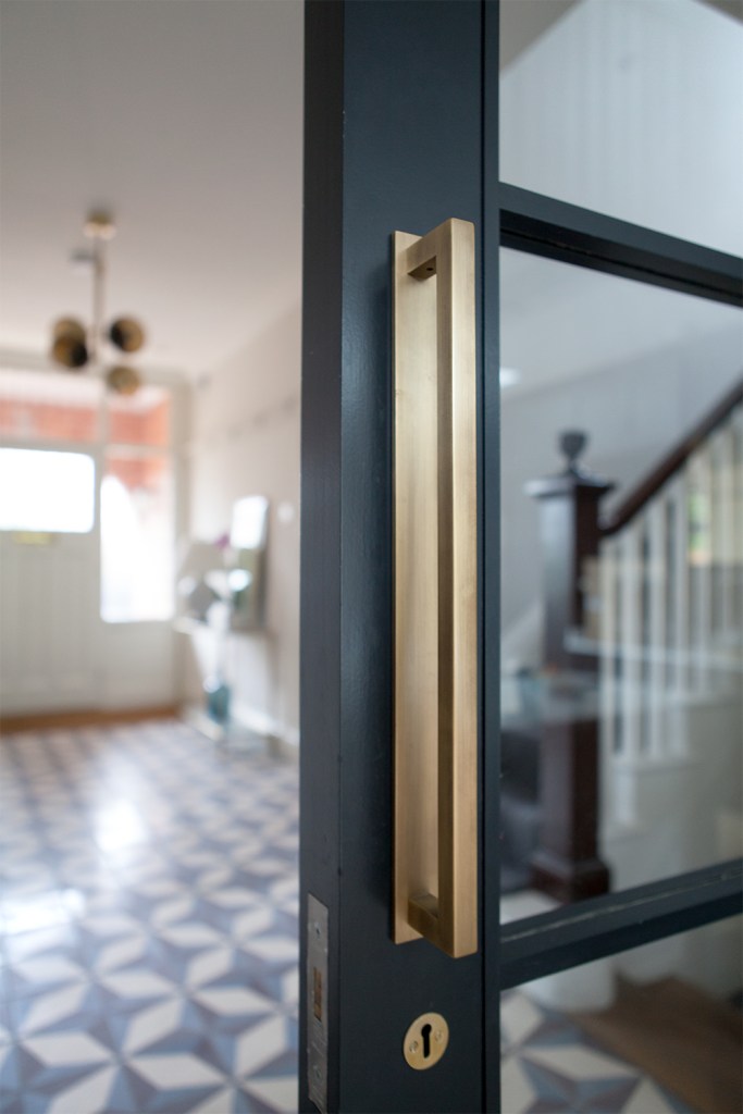 Golden long door handle - golden door key cylinder - door handle detail - glass door