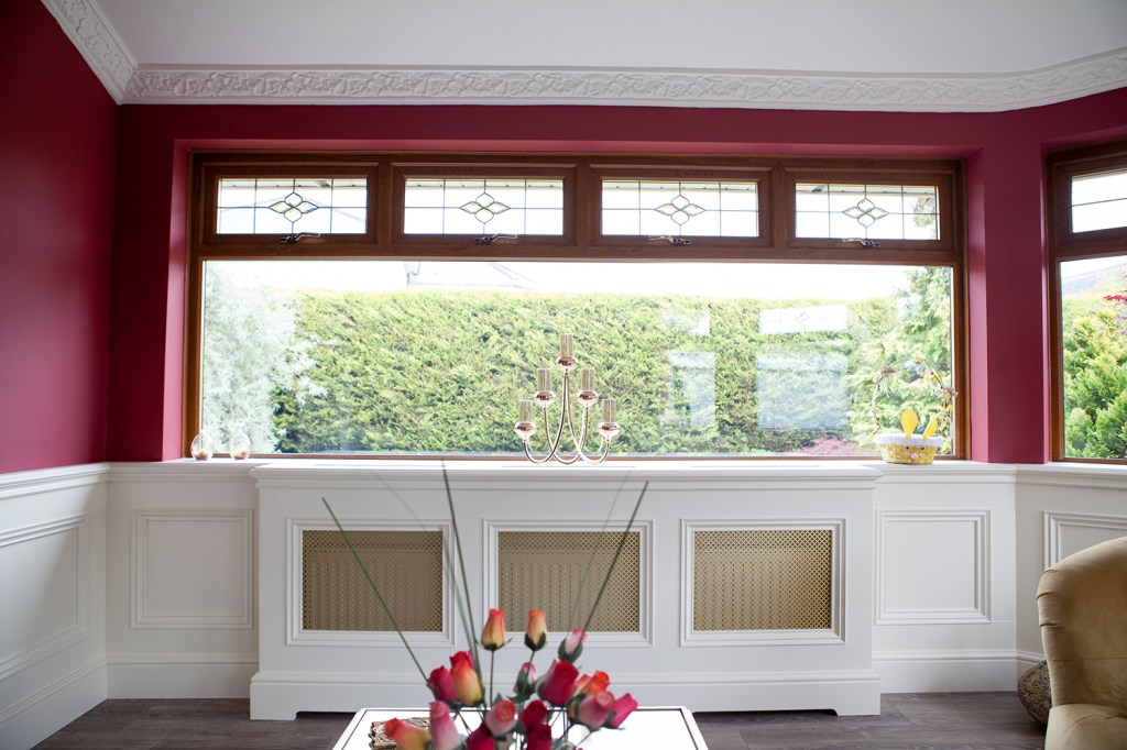 Window above radiator cover - clerestory windows with details - half white wall and half painted wall - closed roses on coffee table - clear window
