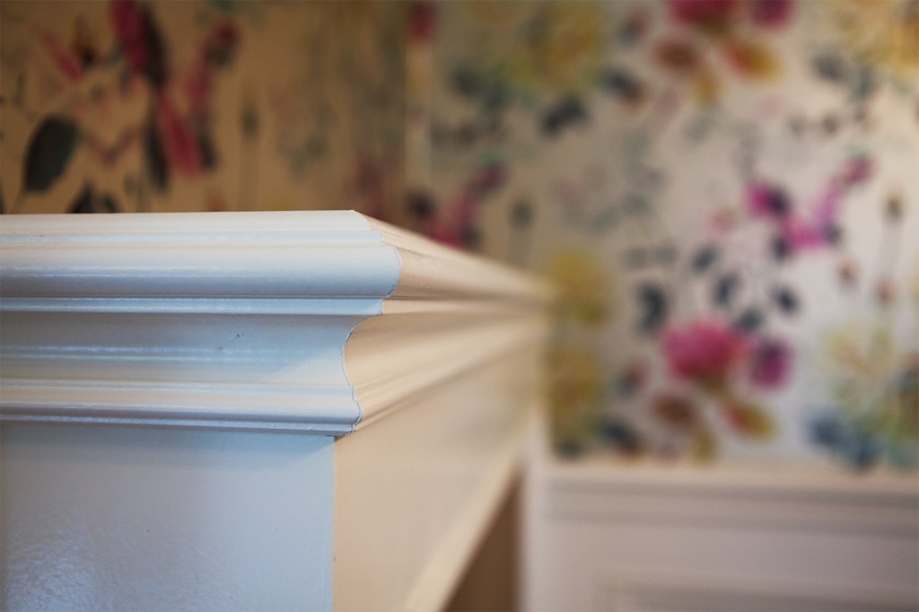 Corner detail of radiator cover - white wood with carving - close up photo