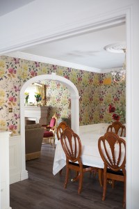 Flower wall paper with white arch and dining room table with chairs - white roof - half white wall