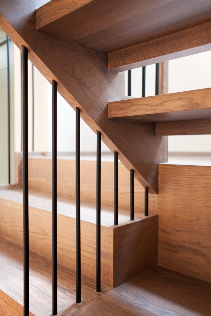 View of under wooden stair tread - iron balustrade - wooden tread