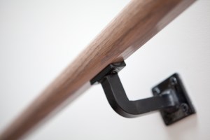 Staircase handrail close up - black handrail bracket - wood handrail