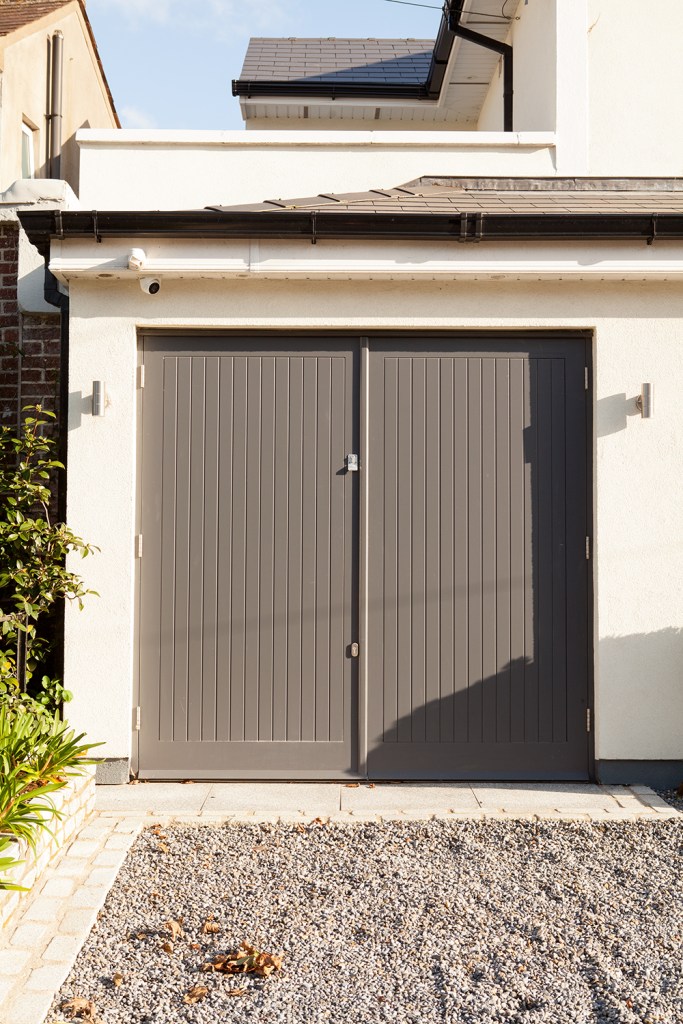 Black single garage door - white house - gravel - double door