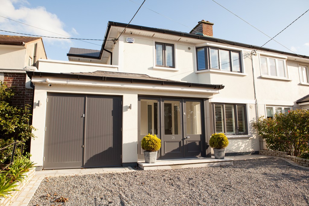 white house - black garage door - house front - glass door - glass door frame - gravel