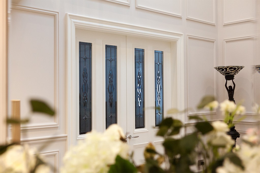 white roses - double door with decorative windows - white door frame - frame carving - white walls