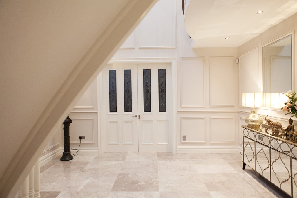 Double white door - transom windows - windows in door - decorative windows - white tile floor - white walls - gold decorative