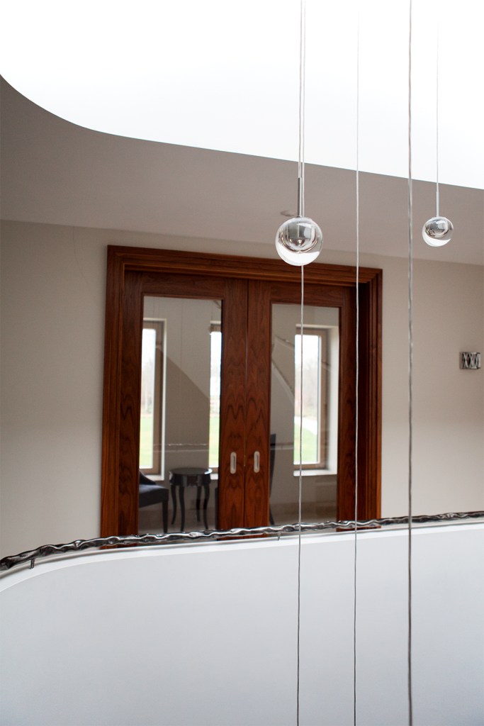 veranda view of double sliding door - dark wood stained door frame - transom window door - railing - hanging decoration