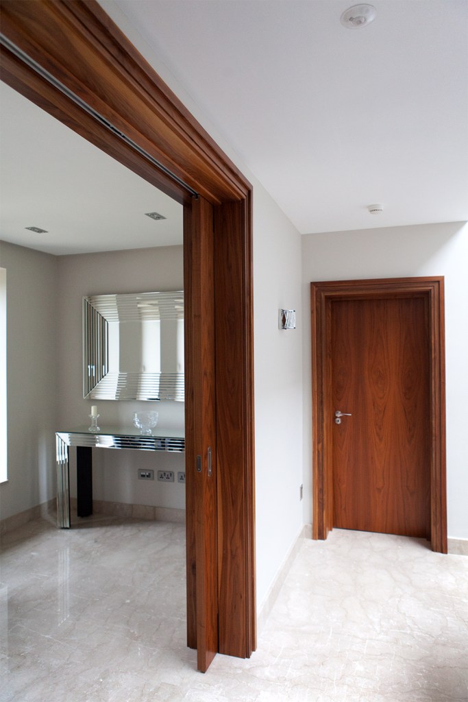 pocket sliding door - open sliding door - stained wood door - stained wood door frame - miror
