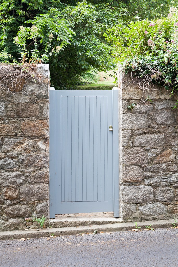 Grey gate - stone walls - greenery - tree's - vines