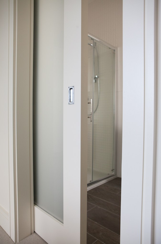Sliding bathroom door - white sliding door - bathroom - white walls - shower