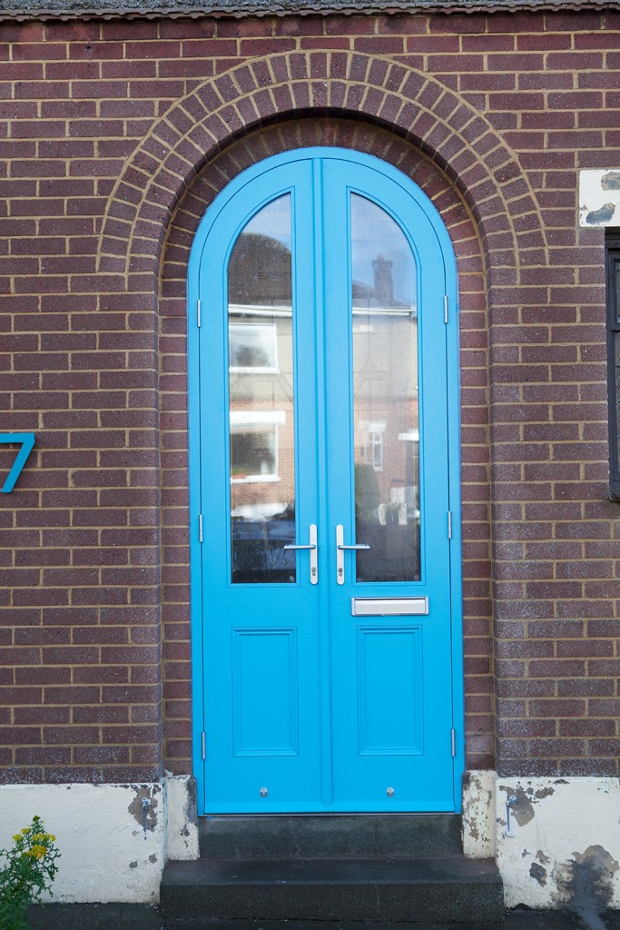 Blue door - door with windows - arched door - brick wall - brick arch